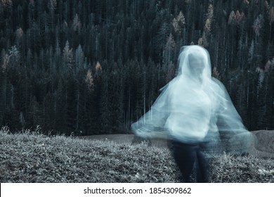 Long Exposure Shot Of Subject In Movement, Creating A Ghost Or Spirit Or Ectoplasm Appearing Just Outside A Thick Forest.