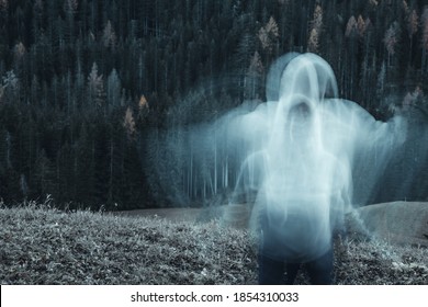 Long Exposure Shot Of Subject In Movement, Creating A Ghost Or Spirit Or Ectoplasm Appearing Just Outside A Thick Forest.