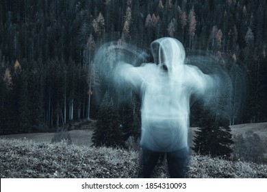 Long Exposure Shot Of Subject In Movement, Creating A Ghost Or Spirit Or Ectoplasm Appearing Just Outside A Thick Forest.