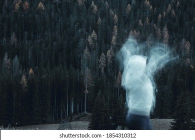 Long Exposure Shot Of Subject In Movement, Creating A Ghost Or Spirit Or Ectoplasm Appearing Just Outside A Thick Forest.