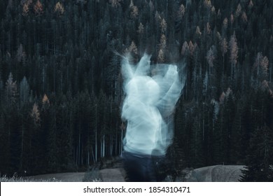 Long Exposure Shot Of Subject In Movement, Creating A Ghost Or Spirit Or Ectoplasm Appearing Just Outside A Thick Forest.