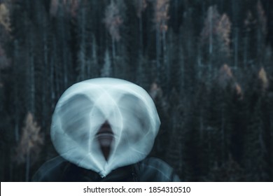 Long Exposure Shot Of Subject In Movement, Creating A Ghost Or Spirit Or Ectoplasm Appearing Just Outside A Thick Forest.