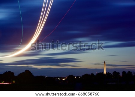 Long exposure showing the flight path of an aircraft on the River Visual approach to runway one-nine at Washington National Airport DCA with the Washington Monument also captured in frame