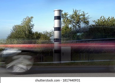 Long exposure at a speed measuring device and a fast passing car in motion blur, automatic traffic monitoring with light radar and camera to punish speeding with fines or revocation of driving license