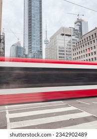 Long exposure of the streetcar in Toronto, with the CN Tower in the background.
