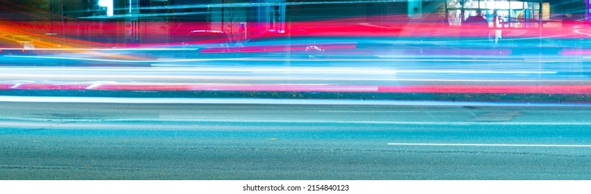 long exposure tracer cars lights. blue and red color lines from vehicles headlights. blurred fast moving transport. night city road traffic. abstract vibrant color dark time city life wide picture.