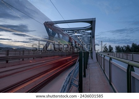 A long exposure of the traffic with blurred tram on the old bridge over the Danube river in the evening. Bratislava, Slovakia