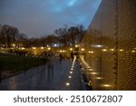 long exposure of Vietnam Veterans Memorial with people walking along the Vietnam Wall at night, Vietnam War