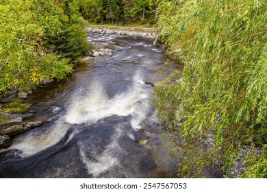 A long exposure view down the Corner Brook Stream from a pedestrian bridges at Corner Brook in Newfoundland, Canada in the fall