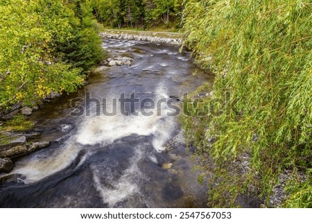 A long exposure view down the Corner Brook Stream from a pedestrian bridges at Corner Brook in Newfoundland, Canada in the fall