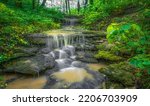 A long exposure waterfall flowing over rocky surface in Cherokee Park, Louisville, Kentucky, United States