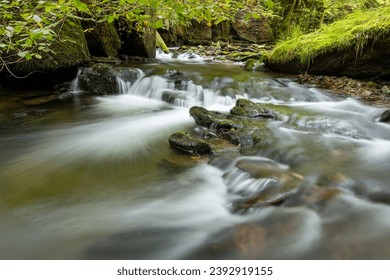 Long exposure of a waterfall on the Hoar Oak Water river at Watersmeet in Exmoor National Park - Shutterstock ID 2392919155