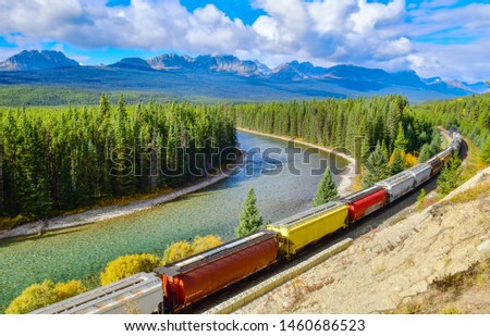Long freight comtainer train moving along Bow river in Canadian Rockies ,Banff National Park, Canadian Rockies,Canada