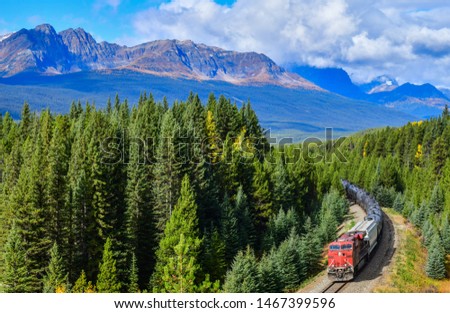 Long freight comtainer train moving along Bow river in Canadian Rockies ,Banff National Park, Canadian Rockies,Canada