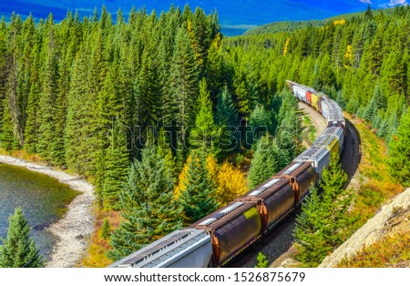 Long freight comtainer train moving along Bow river in Canadian Rockies ,Banff National Park, Canadian Rockies,Canada