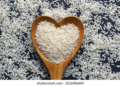 Long grain rice in heart shaped spoon. Flat lay - Shutterstock ID 2216986609
