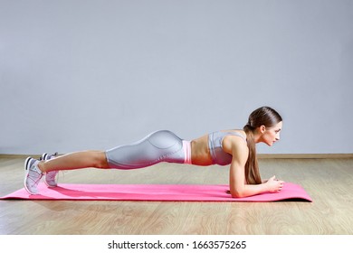 Long Hair Female Doing Plank Static Exercise In Gym Lying On Mat