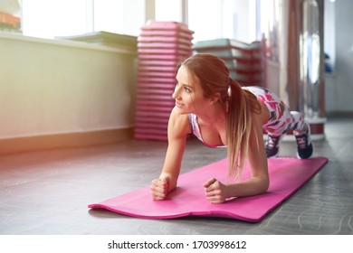 Long Hair Female Doing Plank Static Exercise In Gym Lying On Mat