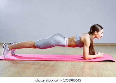 Long Hair Female Doing Plank Static Exercise In Gym Lying On Mat