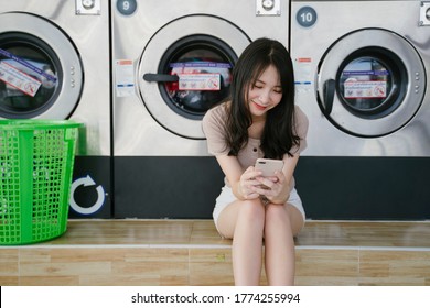 Long hair girl sitting on the floor in front of washing machine waiting for her clothes. - Powered by Shutterstock