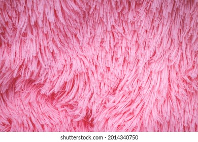 Long Hair Pink Furry Carpet Texture. Decorative Pink Dyed Sheepskin Long Hair Rug. Pink Fluffy Fur, Fashion Background. Fashionable Rose Color Fur Texture. 