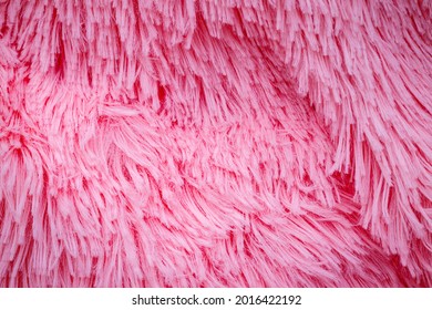 Long Hair Pink Furry Carpet Texture. Pink Fluffy Fur, Fashion Background. Fashionable Rose Color Fur Texture. Decorative Pink Dyed Sheepskin Long Hair Rug.