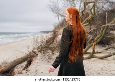 long hair redhead viking girl from the back on the beach