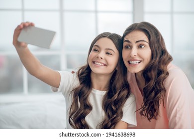 Long Haired Adorable Mom And Daughter Taking Selfie