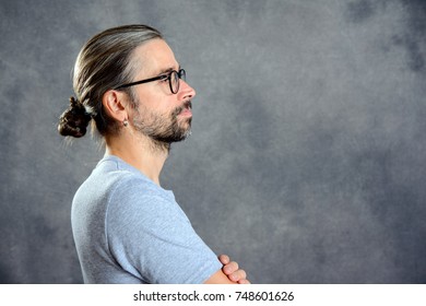 long haired young man with bun looking sideways  - Powered by Shutterstock