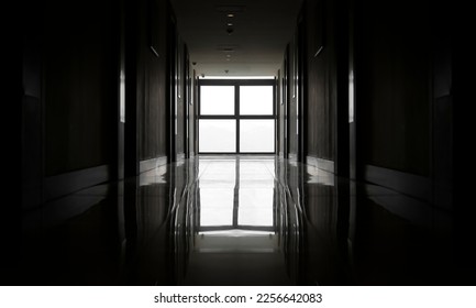 Long hallway of a hotel with many doors. Very long corridor. concrete walls in perspective. Dim lighting. Selective focus. big window in the end. natural daylight. fire alarm video surveillance.