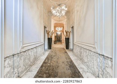 a long hallway with marble flooring and chandels on either side of the hall, as seen from the entrance way