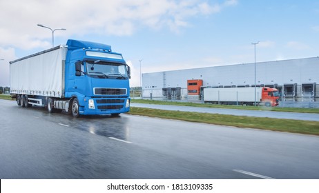 Long Haul Semi-Truck with Cargo Trailer Full of Goods Travels on the Highway Road. Daytime Driving Across Continent Through Rain. Industrial Retail Warehouses Area. Front Shot - Shutterstock ID 1813109335
