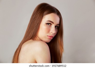 Long Healthy Straight Hair. Beauty Woman With Long Shiny Brown Hair. Model Brunette Portrait Isolated On A Gray Background.