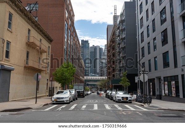 Long Island City Queens, New York / USA - May 4\
2020: Street with Skyscrapers and a view of the Elevated Subway in\
Long Island City Queens