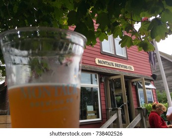 Long Island, NY - Circa 2017: Montauk Brewing Company Building In Background Of Brand Cup For Beer Sample At Outside Beer Garden To Sample And Taste New Flavor Product