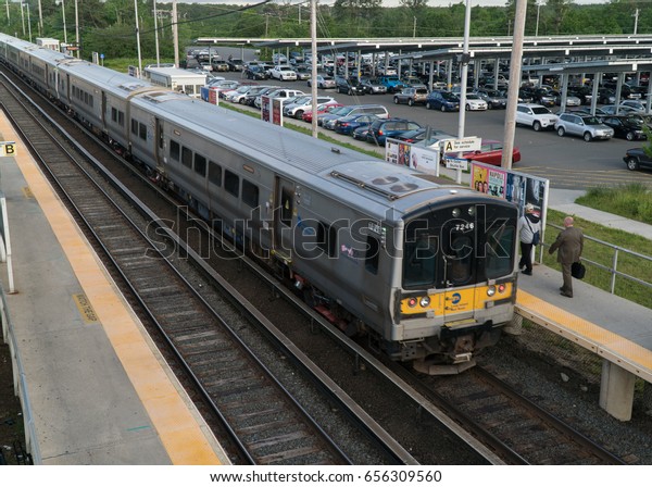 Long Island, NY - Circa 2017: Long Island\
Railroad LIRR train depart local station platform to commute\
passengers travel Penn Station New York\
City