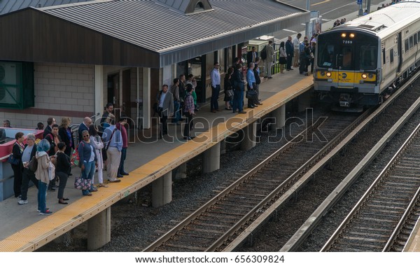 Long Island, NY - Circa 2017: Long Island\
Railroad LIRR train arrive local station platform to commute\
passengers travel Penn Station New York\
City