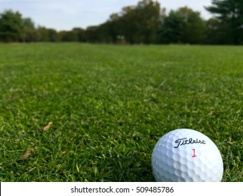Long Island, NY - October 2016: Titleist golf ball on the fairway grass before hit towards the green on a beautiful course in autumn. Illustrative Editorial.