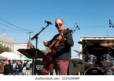 Long Island, NY, USA-October 9, 2022 A Man Playing A Guitar Outside During A Street Fair 