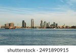 Long Island skyscrapers and East River from East River Promenade in New York, USA. Views at dawn with the first rays of a barge sailing and in the background the buildings and skyscrapers.