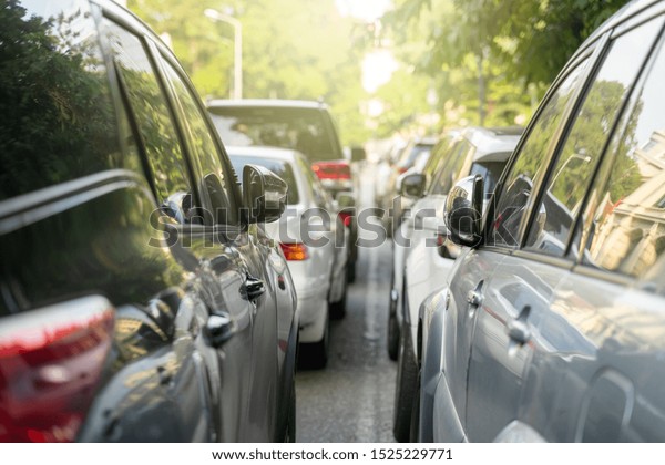 Long line of\
cars on urban street with rear\
view