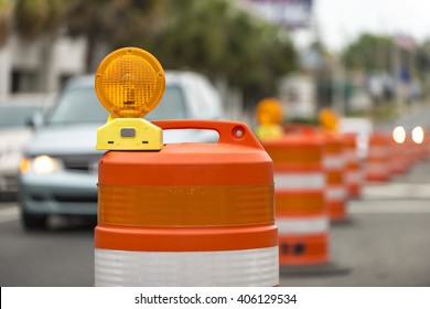 long line orange traffic barrier barrels to detour traffic around construction zone shallow depth field