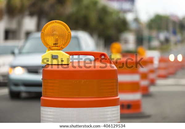 long line of\
orange traffic barrier barrels to detour traffic around\
construction zone shallow depth of\
field