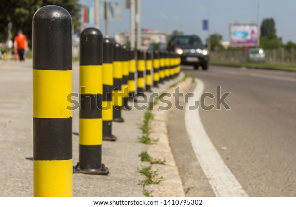 long line of yellow and black traffic signs to\
deter the cars around the\
road.