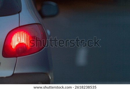 A long and linedup queue of numerous cars on a bustling city street during evening or night