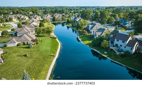 Long manmade pond between houses in neighborhood aerial