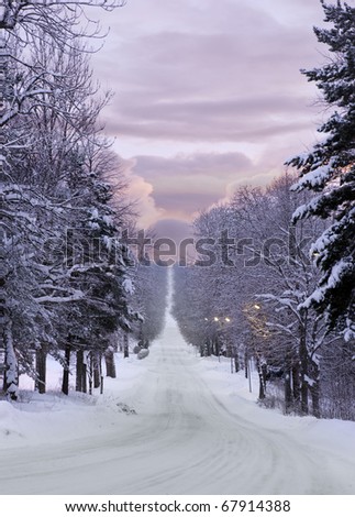 Long narrow road over a hill in purple evening winter light