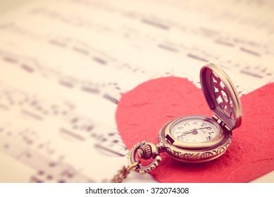 Long necklace antique style pocket watch with a red mulberry paper heart on sheet music. A symbol to express someone eternal love on special occasions i.e. Valentines day, Fathers & Mothers Day.