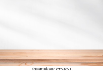 Long Pine Wooden Table In Front Of Wall With Soft Light. Empty Desk, Shelf Or Tabletop For Template. 