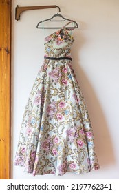 A Long Pink With Flower Bridesmaid Dress With Embroidery And Sequins Is On A Hanger On The Wall